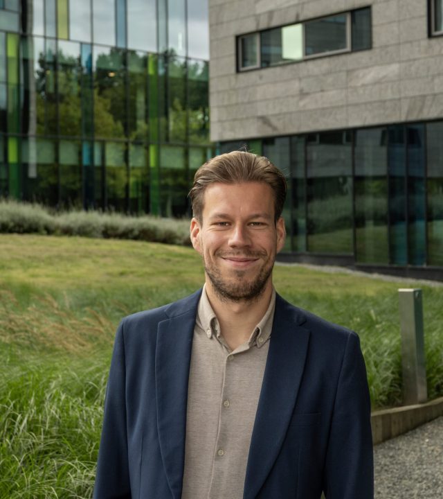 Man in suit near modern building.